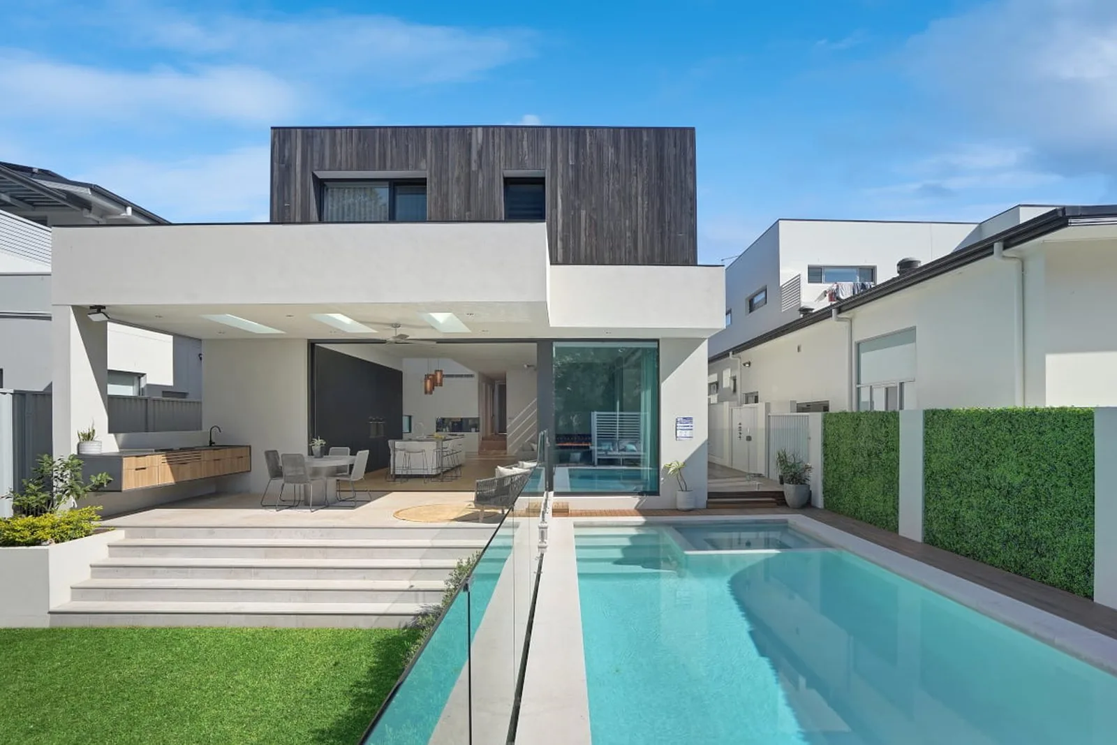 Completed new-build family home with a rendered lower façade and dark upper-level cladding